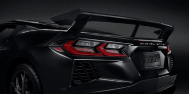 Close-up view of a sleek red sports car showcasing its rear engine cover, featuring a distinctive design and vent details that enhance aerodynamics and performance.