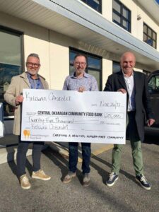 Kelowna Chevrolet representatives present a large donation check for $25,000 to the Central Okanagan Community Food Bank, emphasizing support for a healthy, hunger-free community.