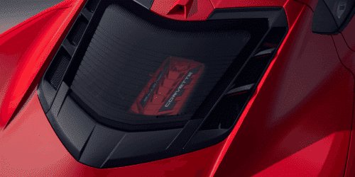 Close-up view of a sleek red sports car showcasing its rear engine cover, featuring a distinctive design and vent details that enhance aerodynamics and performance.