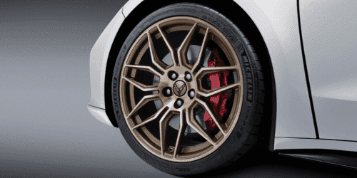 Close-up view of a sleek red sports car showcasing its rear engine cover, featuring a distinctive design and vent details that enhance aerodynamics and performance.