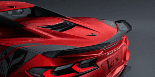 Close-up view of a sleek red sports car showcasing its rear engine cover, featuring a distinctive design and vent details that enhance aerodynamics and performance.