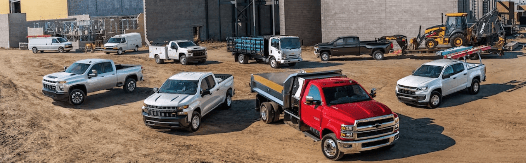 Chevrolet and GMC trucks displayed in front of a construction site, emphasizing strength and business capability, with a tagline highlighting a new look for business elite.