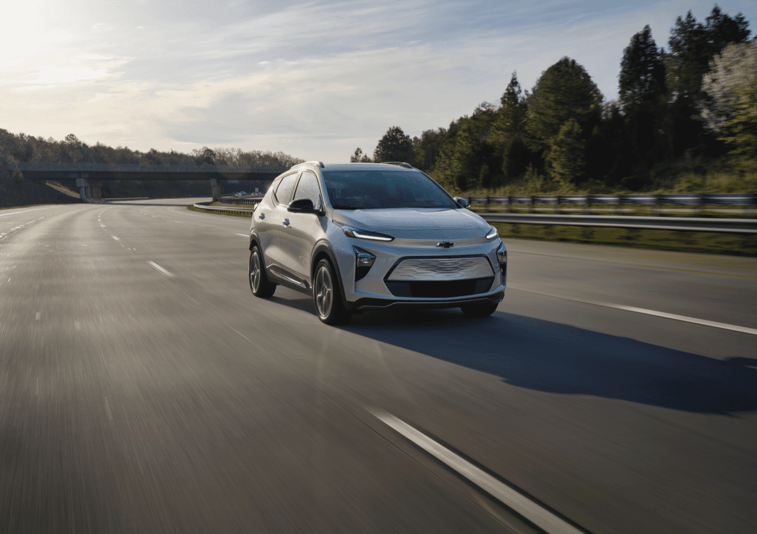 Modern Chevy electric SUV parked in front of a contemporary building, showcasing sleek lines and innovative design. The vehicle stands out with its aerodynamic shape and stylish wheels, emphasizing its advanced technology and eco-friendly features.