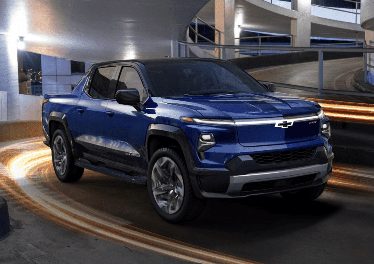Modern Chevy electric SUV parked in front of a contemporary building, showcasing sleek lines and innovative design. The vehicle stands out with its aerodynamic shape and stylish wheels, emphasizing its advanced technology and eco-friendly features.